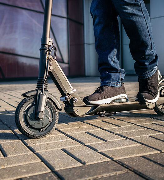 E-scooter driver on a sidewalk in California